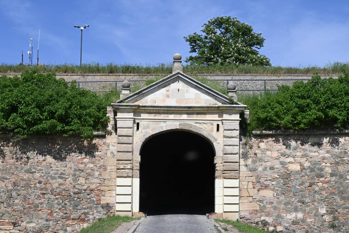 Entrée voûtée de la forteresse de Petrovaradin à Novi Sad entourée de murs en pierre et de verdure