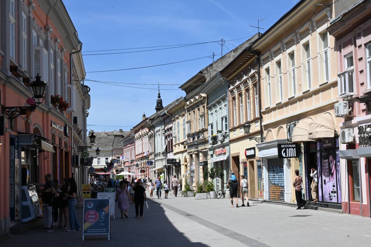 Rue piétonne animée de Novi Sad avec boutiques, façades pastel et ambiance printanière